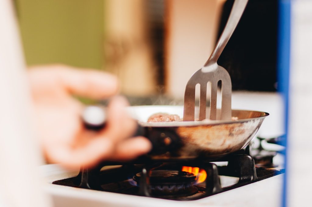 Woman at home cooking in the kitchen in gas stove