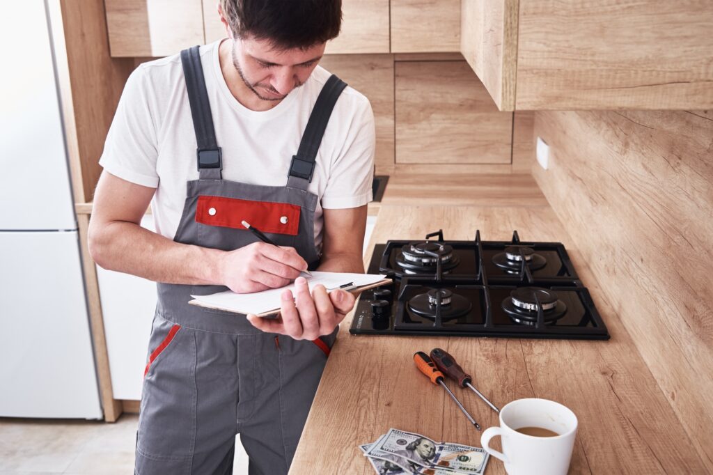Plumber signs a contract for the services in the kitchen