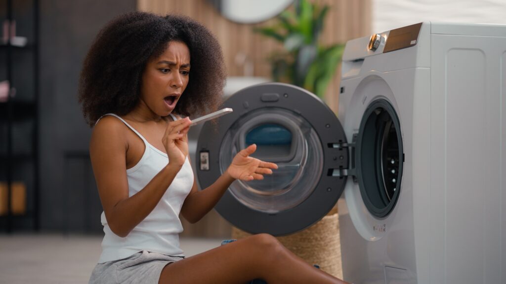 African American girl ethnic lady biracial woman housewife home laundry clothes open washing machine