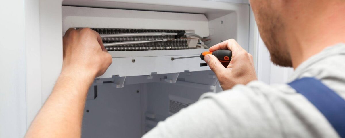 A technician is fixing an air conditioning unit using tools to address the issue