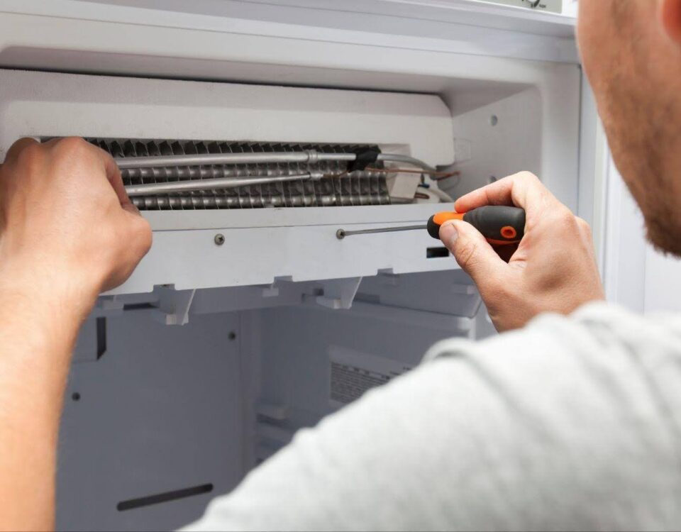 A technician is fixing an air conditioning unit using tools to address the issue