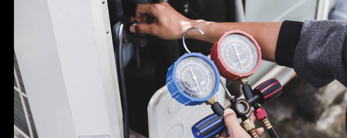 A technician holds a gauge near a gas furnace assessing its pressure for safety and efficiency