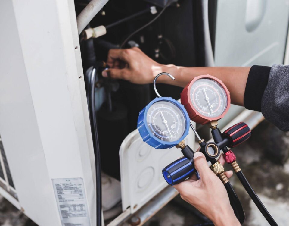 A technician holds a gauge near a gas furnace assessing its pressure for safety and efficiency